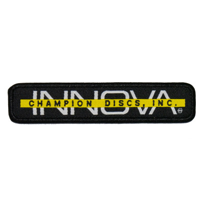 Innova Bar Stamp Patch. Shows a long rectangular patch with black background. The word INNOVA is white and capitalized, and a yellow bar goes across center of the letters. The bar has "Champion Discs" written in black.